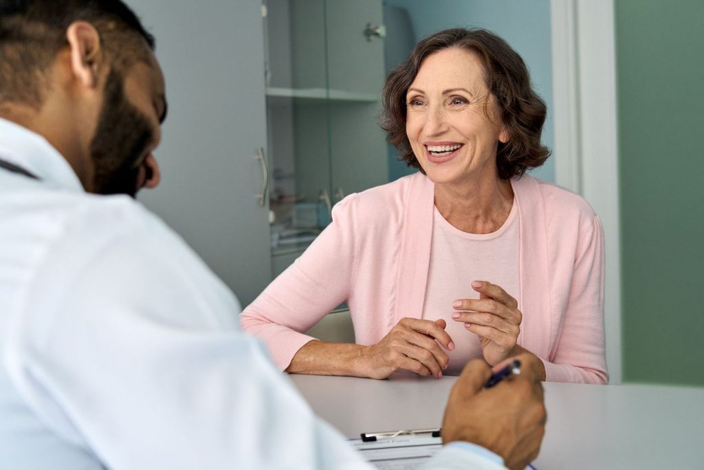 Female brunette patient talking with her physician at a desk